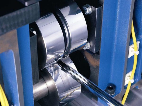 A machine that is cutting metal pipes.